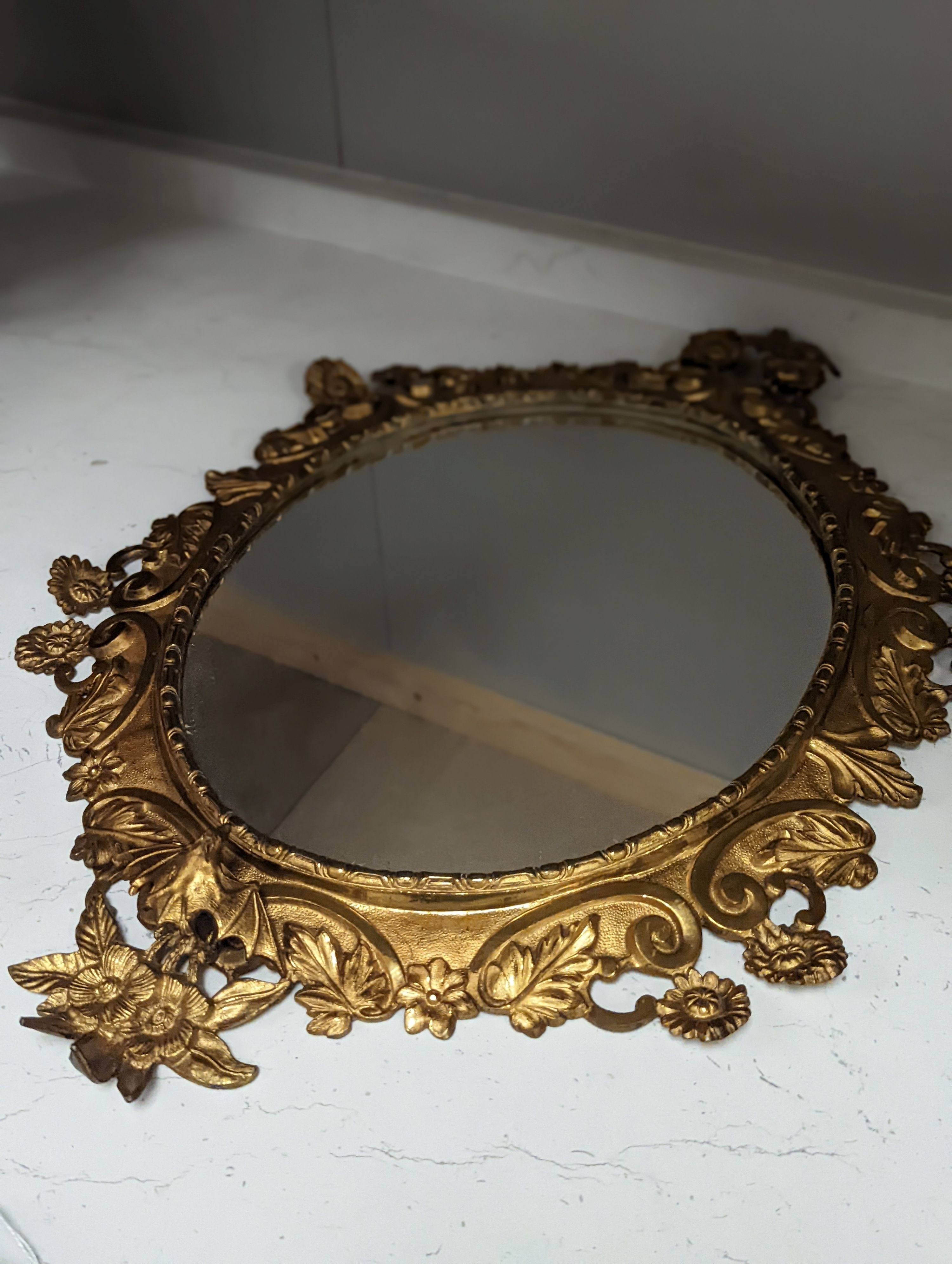 A pair of gilt brass wall mirrors, decorated with bats and flowers 56cm